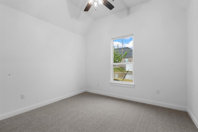 carpeted empty room featuring baseboards, lofted ceiling, and a ceiling fan