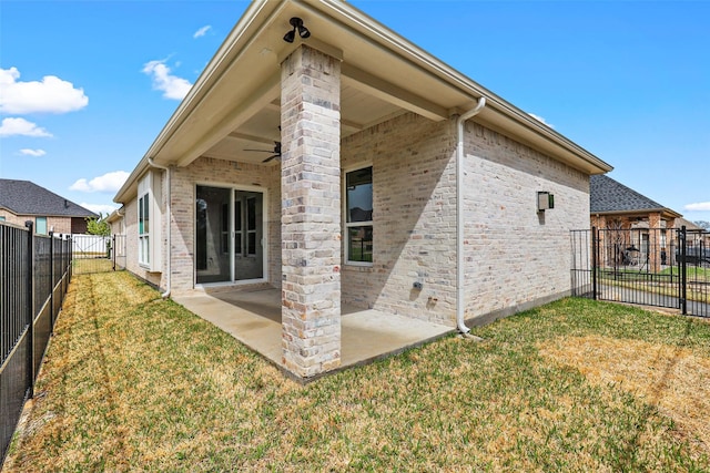 back of property with a lawn, a patio, a fenced backyard, brick siding, and ceiling fan