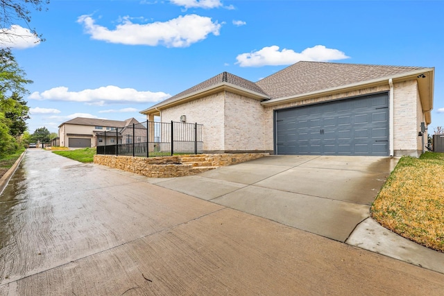 ranch-style home with brick siding, an attached garage, concrete driveway, and a shingled roof