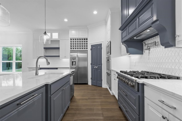 kitchen featuring white cabinetry, custom range hood, built in appliances, and a sink