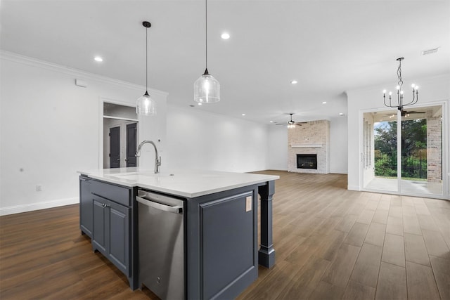 kitchen with visible vents, dark wood-style floors, a kitchen island with sink, and a fireplace