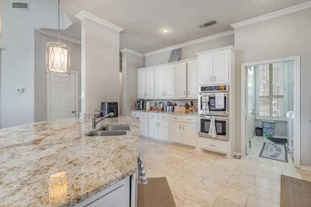 kitchen with a sink, visible vents, light stone counters, and stainless steel double oven