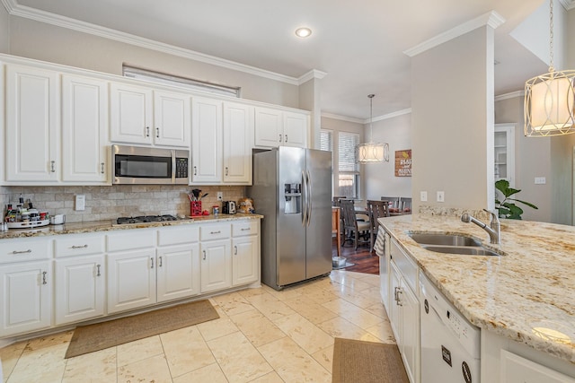 kitchen with tasteful backsplash, crown molding, stainless steel appliances, white cabinetry, and a sink