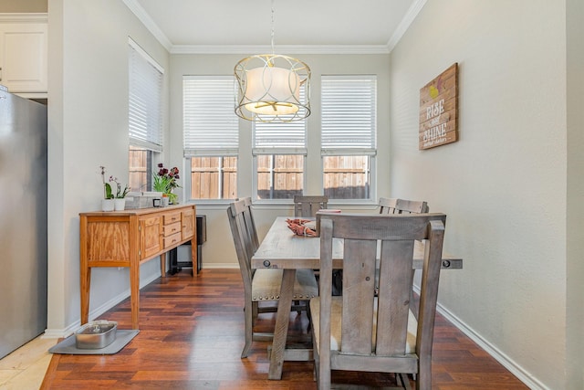 dining space featuring wood finished floors, baseboards, and ornamental molding