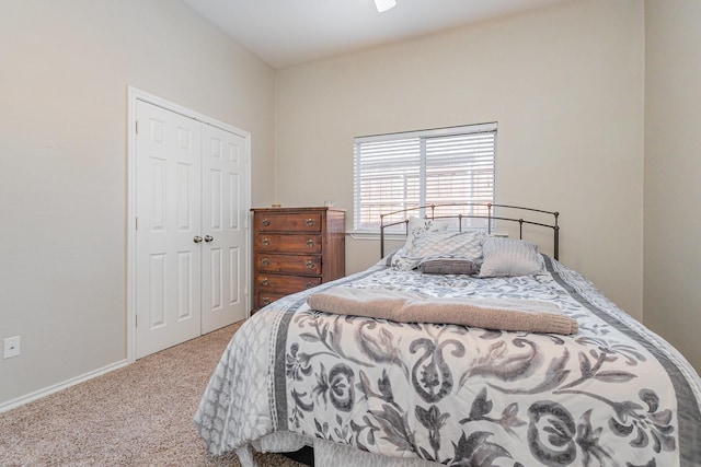 carpeted bedroom featuring a closet and baseboards