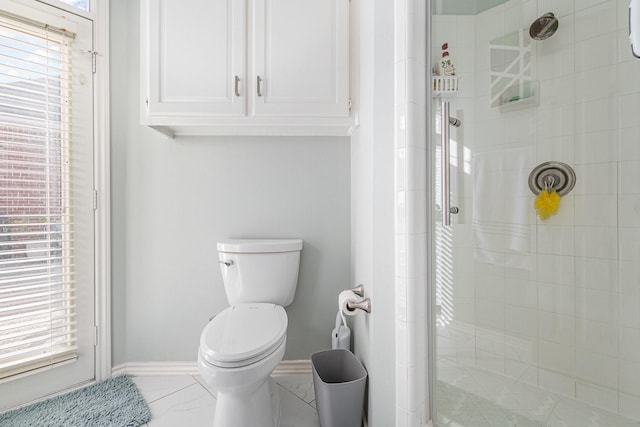 full bathroom with baseboards, toilet, marble finish floor, and a shower stall