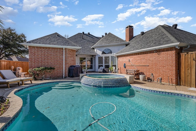 view of pool with a patio, fence, a pool with connected hot tub, and grilling area