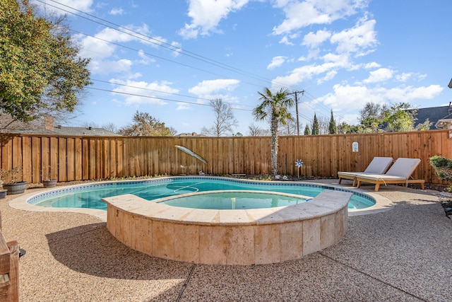 view of pool featuring an in ground hot tub, a fenced backyard, and a patio area