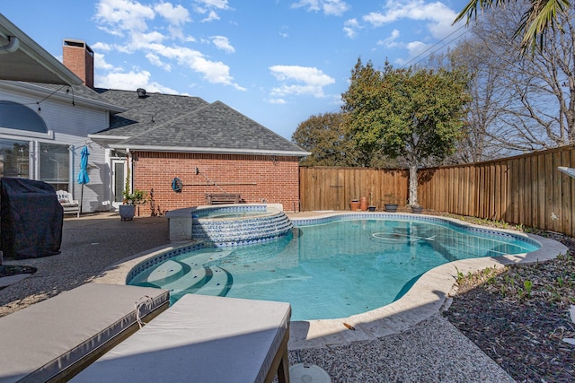 view of swimming pool with grilling area, a pool with connected hot tub, a fenced backyard, and a patio area