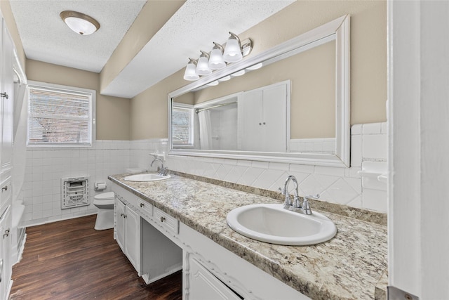 6305 Chapman Dr, Greenville, TX 75402 - bathroom with heating unit, toilet, double vanity, healthy amount of natural light, and wainscoting