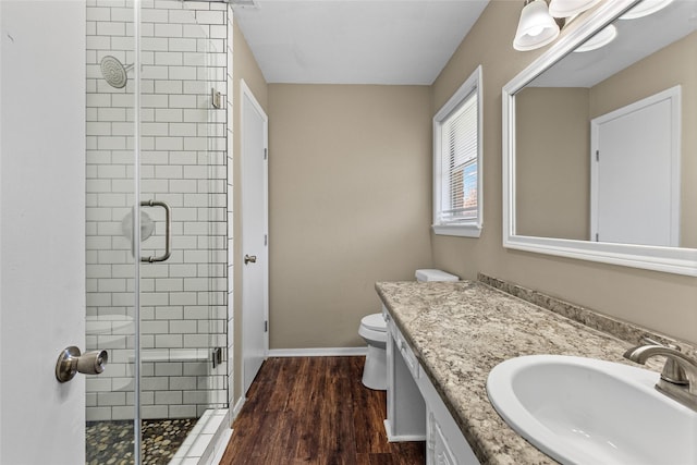 6305 Chapman Dr, Greenville, TX 75402 - bathroom featuring a shower stall, vanity, toilet, wood finished floors, and baseboards