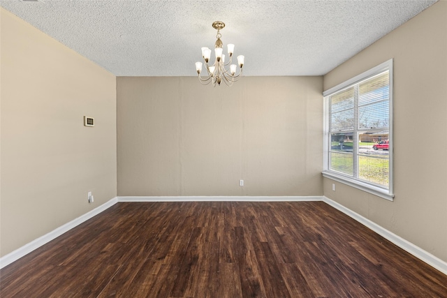 6305 Chapman Dr, Greenville, TX 75402 - unfurnished room with a chandelier, dark wood finished floors, a textured ceiling, and baseboards