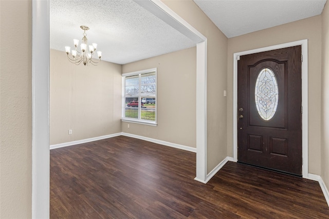 6305 Chapman Dr, Greenville, TX 75402 - entryway with a chandelier, dark wood-style floors, baseboards, and a textured ceiling