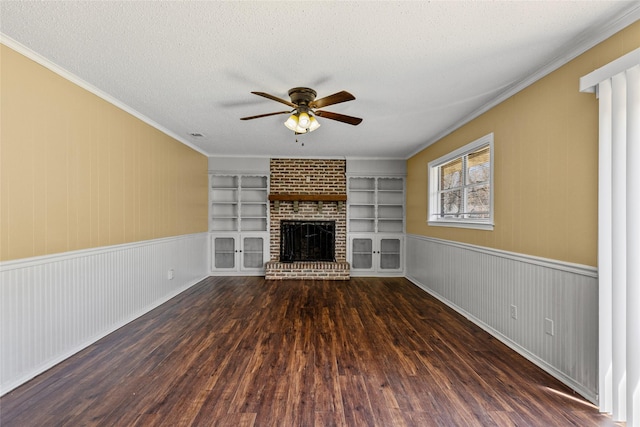 6305 Chapman Dr, Greenville, TX 75402 - unfurnished living room featuring a ceiling fan, wood finished floors, a fireplace, ornamental molding, and a textured ceiling
