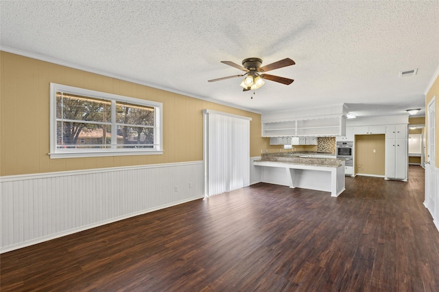 6305 Chapman Dr, Greenville, TX 75402 - unfurnished living room with a ceiling fan, dark wood-type flooring, a textured ceiling, and crown molding