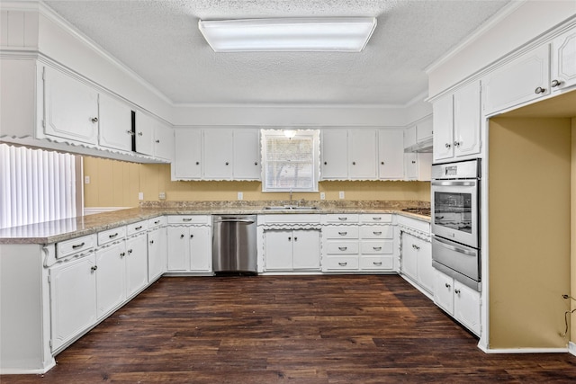 6305 Chapman Dr, Greenville, TX 75402 - kitchen with appliances with stainless steel finishes, a textured ceiling, a sink, a warming drawer, and a peninsula