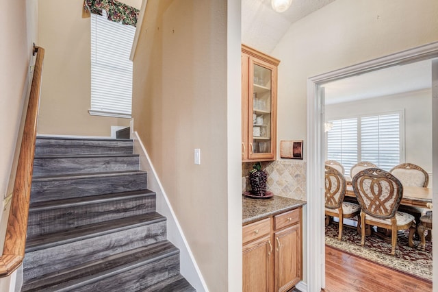 staircase with lofted ceiling and wood finished floors