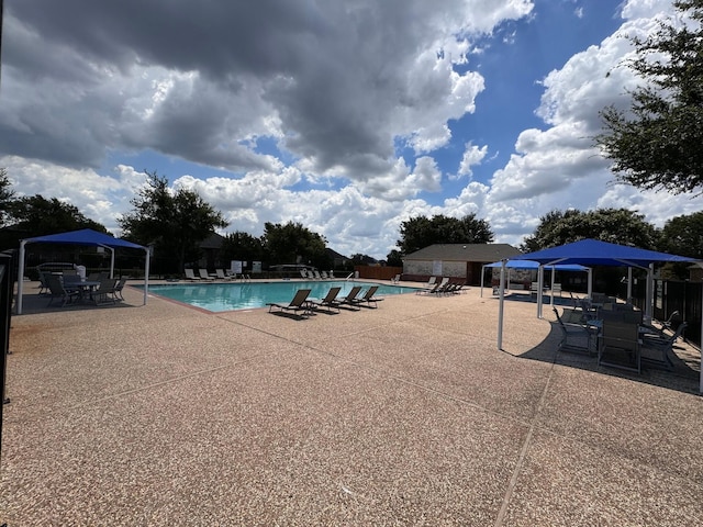 community pool featuring fence and a patio area