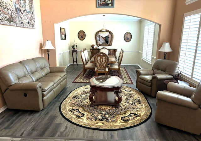 living room with wood finished floors, arched walkways, and baseboards