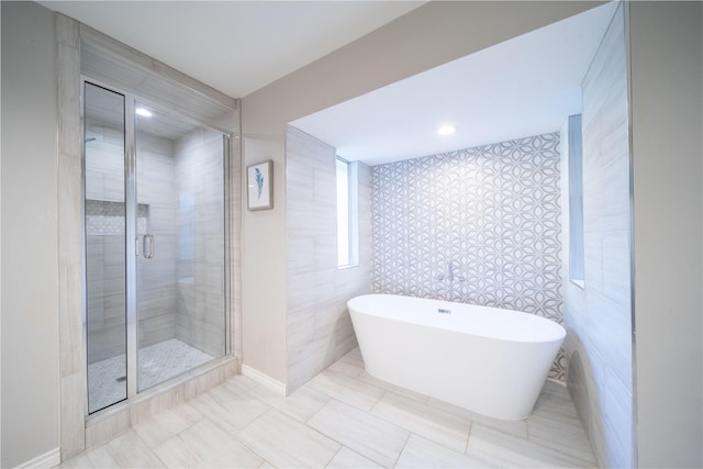 bathroom featuring a freestanding bath, tile walls, and a stall shower