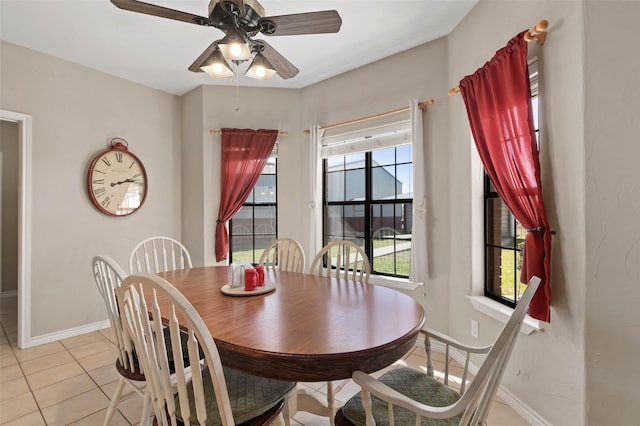 dining space featuring light tile patterned floors, baseboards, and ceiling fan