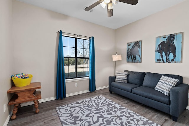 living room with baseboards, wood finished floors, and a ceiling fan