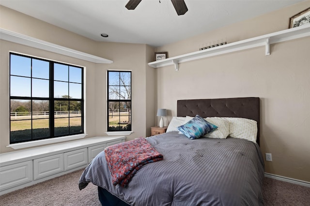 bedroom with a ceiling fan, baseboards, and light carpet