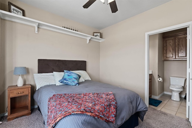 bedroom featuring light tile patterned flooring, light carpet, ensuite bathroom, and a ceiling fan