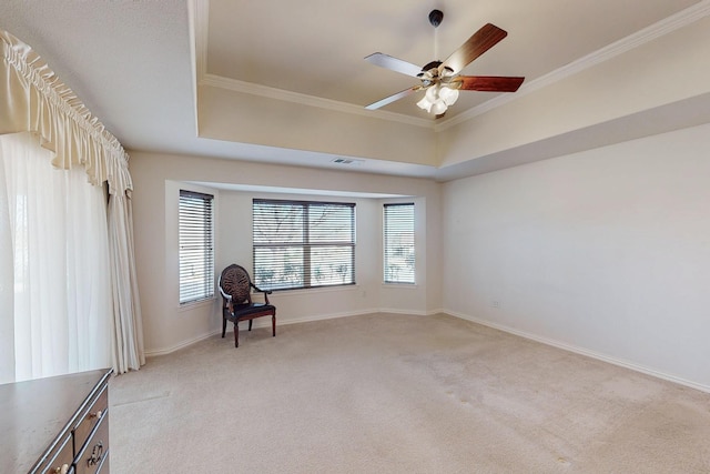 unfurnished room with light colored carpet, crown molding, a raised ceiling, and a ceiling fan