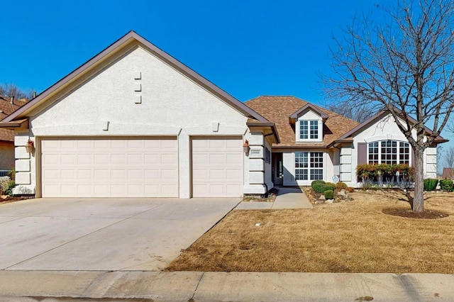 view of front of house with an attached garage, driveway, and stucco siding