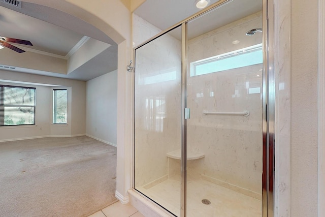 full bath with tile patterned floors, a ceiling fan, ornamental molding, and a shower stall