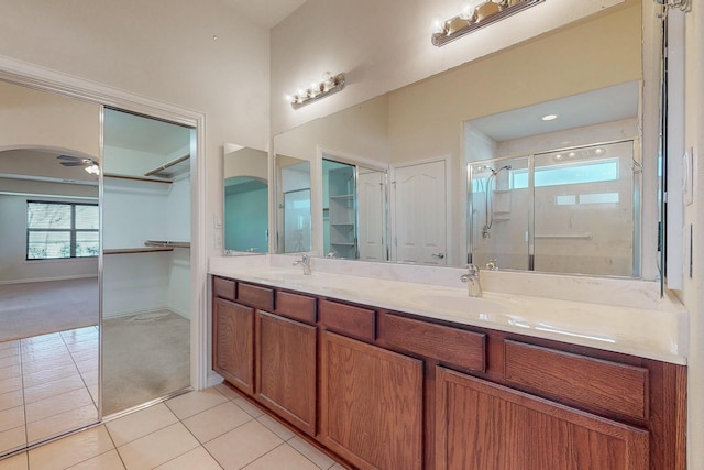 full bath featuring tile patterned flooring, a shower stall, double vanity, and a sink