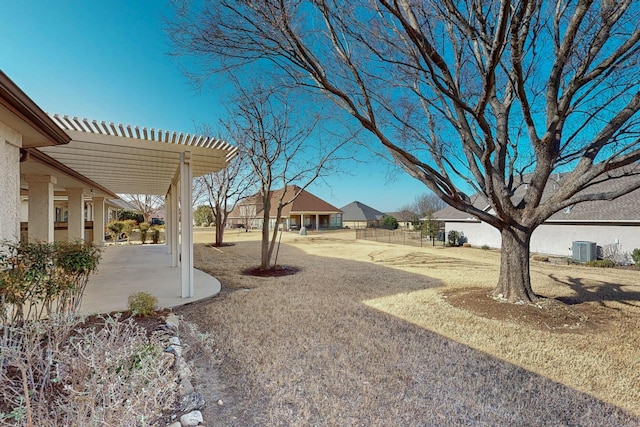 view of yard with a residential view, a patio, central AC unit, and a pergola