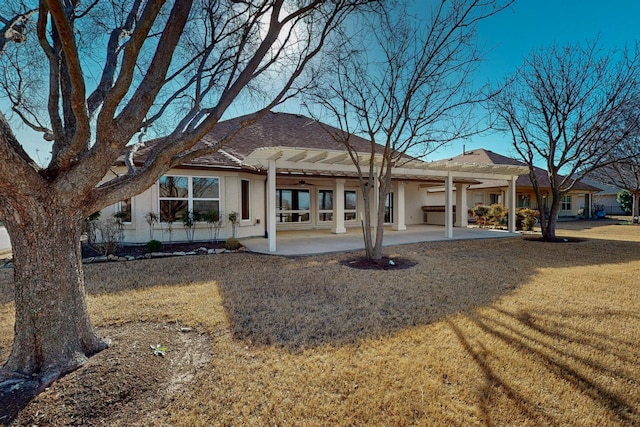 rear view of house featuring a patio area, stucco siding, a yard, and ceiling fan