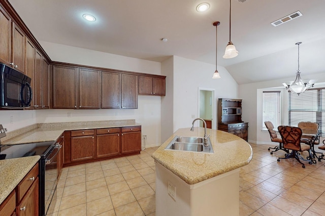 kitchen featuring visible vents, an island with sink, a sink, black appliances, and a notable chandelier