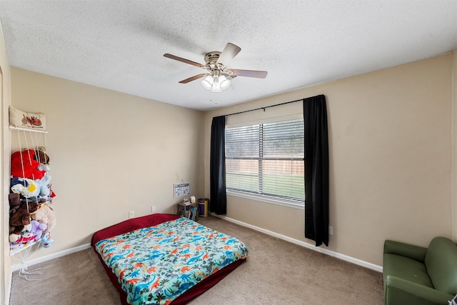 bedroom with carpet flooring, a ceiling fan, baseboards, and a textured ceiling