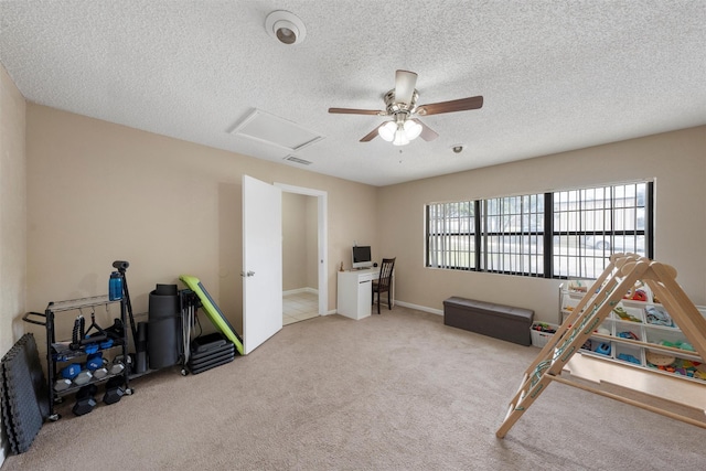 game room with ceiling fan, attic access, carpet, and a textured ceiling