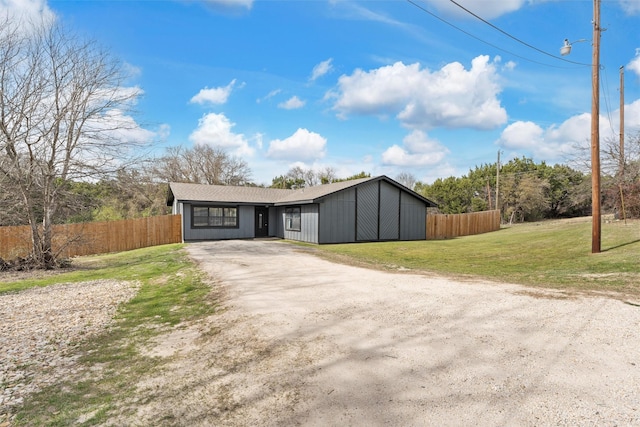 view of front of home featuring a front lawn, driveway, and fence