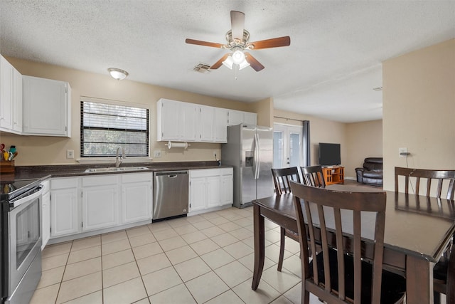 kitchen featuring visible vents, a sink, dark countertops, appliances with stainless steel finishes, and ceiling fan