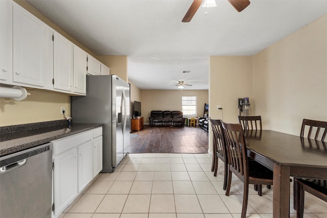 interior space featuring light tile patterned floors, stainless steel appliances, and ceiling fan