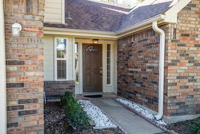 property entrance with brick siding and a shingled roof