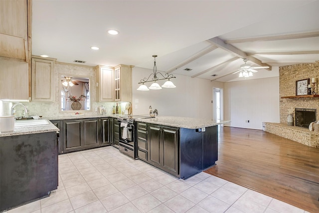 kitchen with lofted ceiling with beams, a peninsula, electric range, a ceiling fan, and a sink