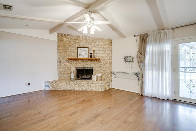 unfurnished living room featuring visible vents, lofted ceiling with beams, a ceiling fan, and wood finished floors