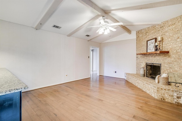 unfurnished living room with visible vents, vaulted ceiling with beams, a ceiling fan, and wood finished floors