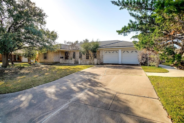 single story home featuring an attached garage, concrete driveway, and a front lawn