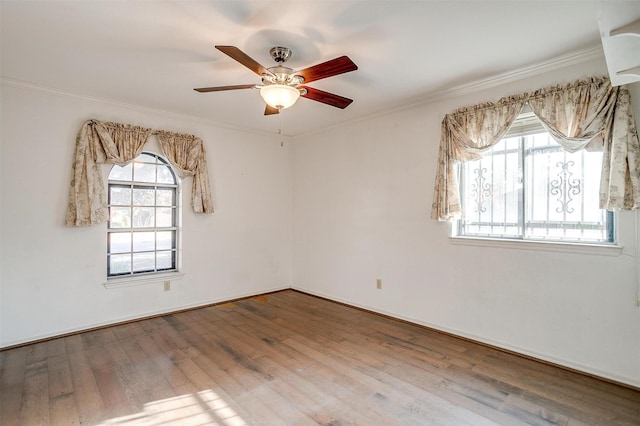 unfurnished room featuring a ceiling fan, crown molding, wood finished floors, and a healthy amount of sunlight