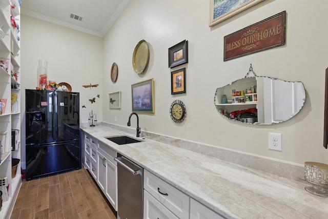 kitchen with a sink, light stone counters, black fridge with ice dispenser, dishwasher, and wood tiled floor