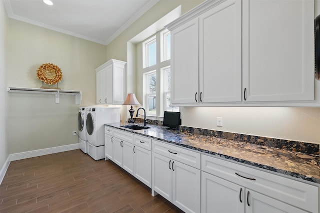 washroom with independent washer and dryer, a sink, dark wood finished floors, cabinet space, and crown molding