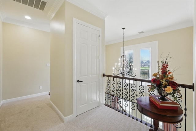 hall with visible vents, baseboards, carpet, ornamental molding, and an inviting chandelier