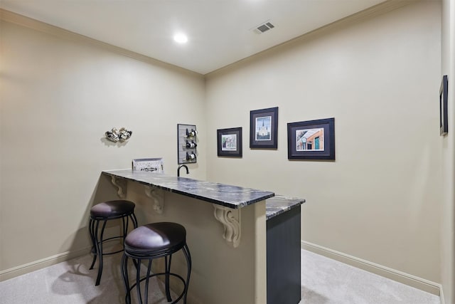 bar with visible vents, baseboards, carpet flooring, and crown molding